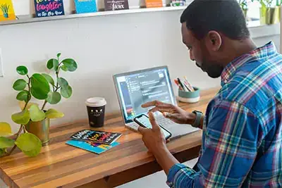 a man using a laptop and a phone