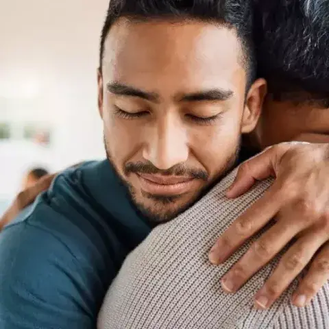 Two men embracing in a warm hug